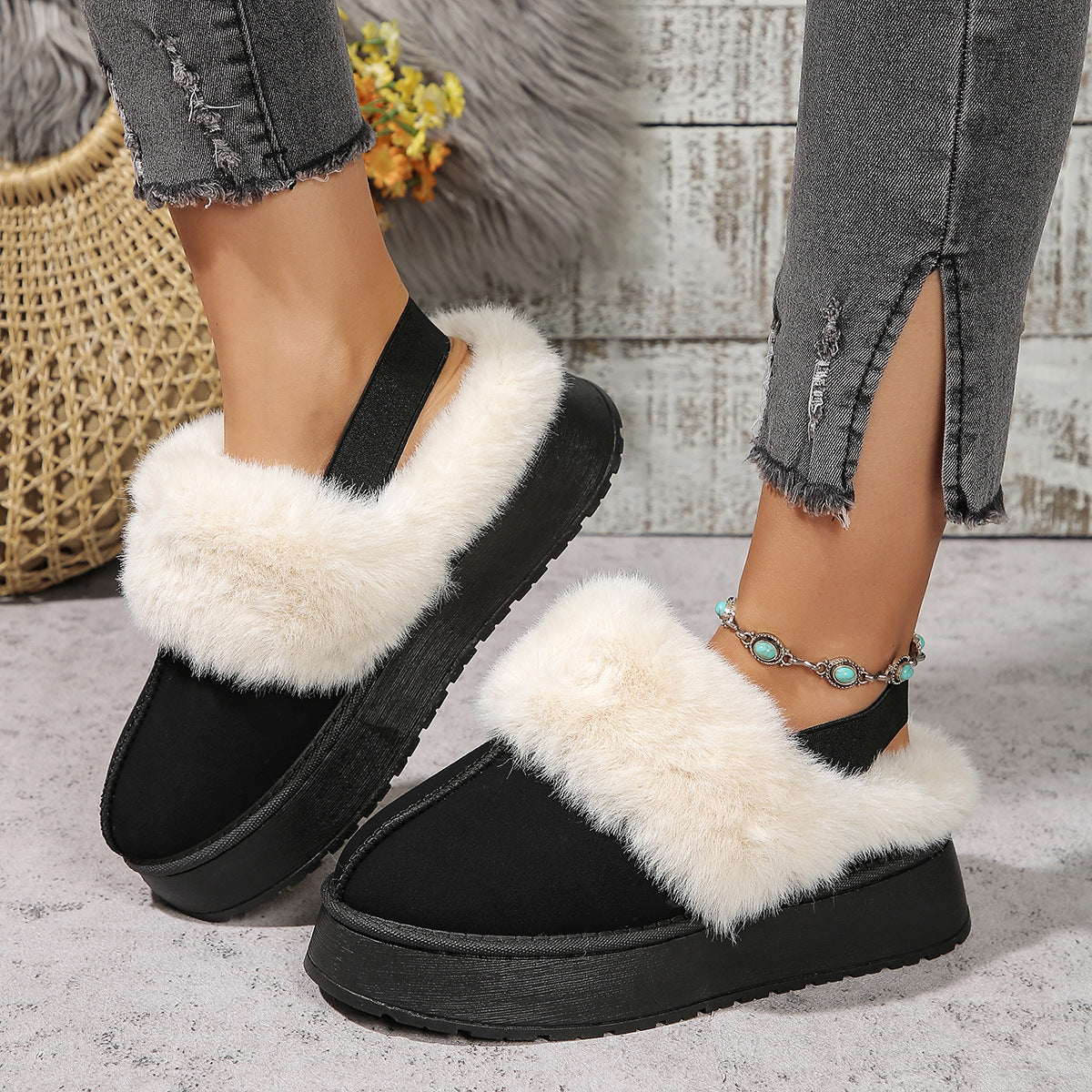 Cozy winter slippers with fluffy lining and elastic heel strap, worn by a model in ripped jeans, perfect for home warmth and style.