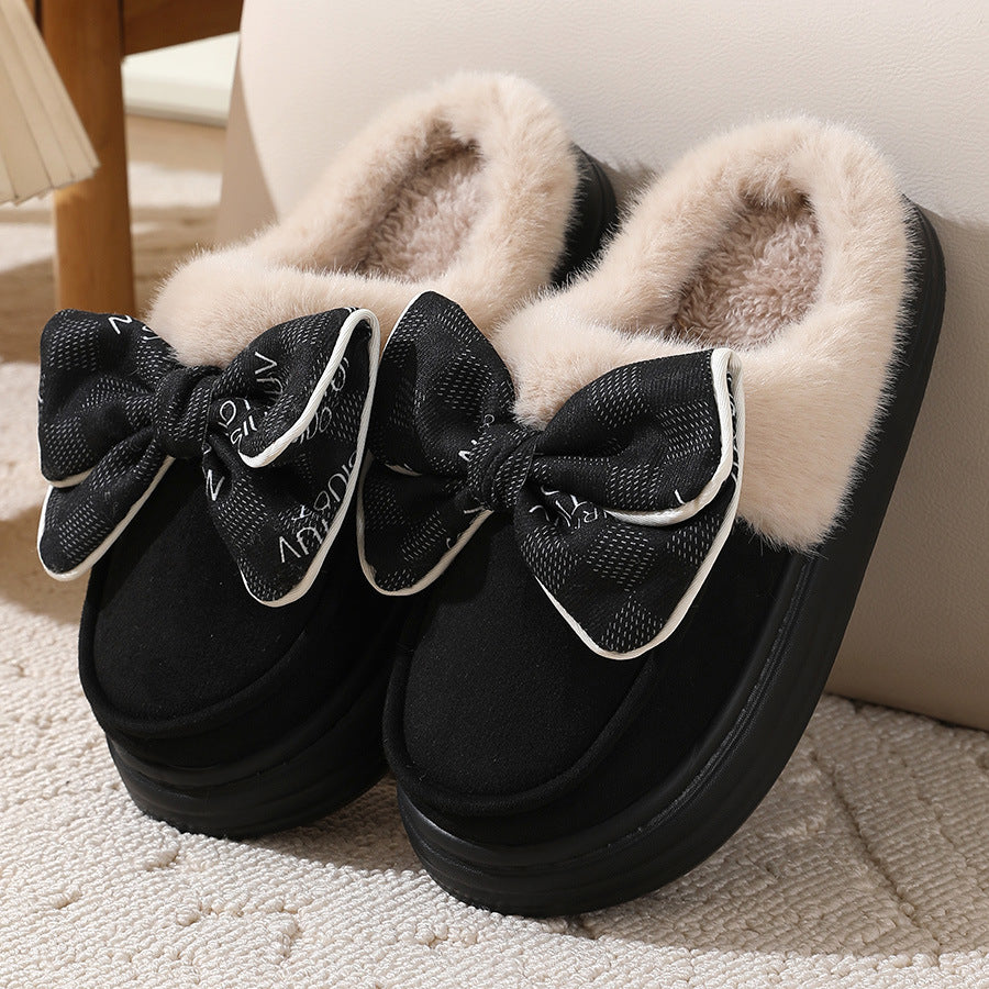 Fluffy winter slippers with black bow on a carpeted floor for warmth and style