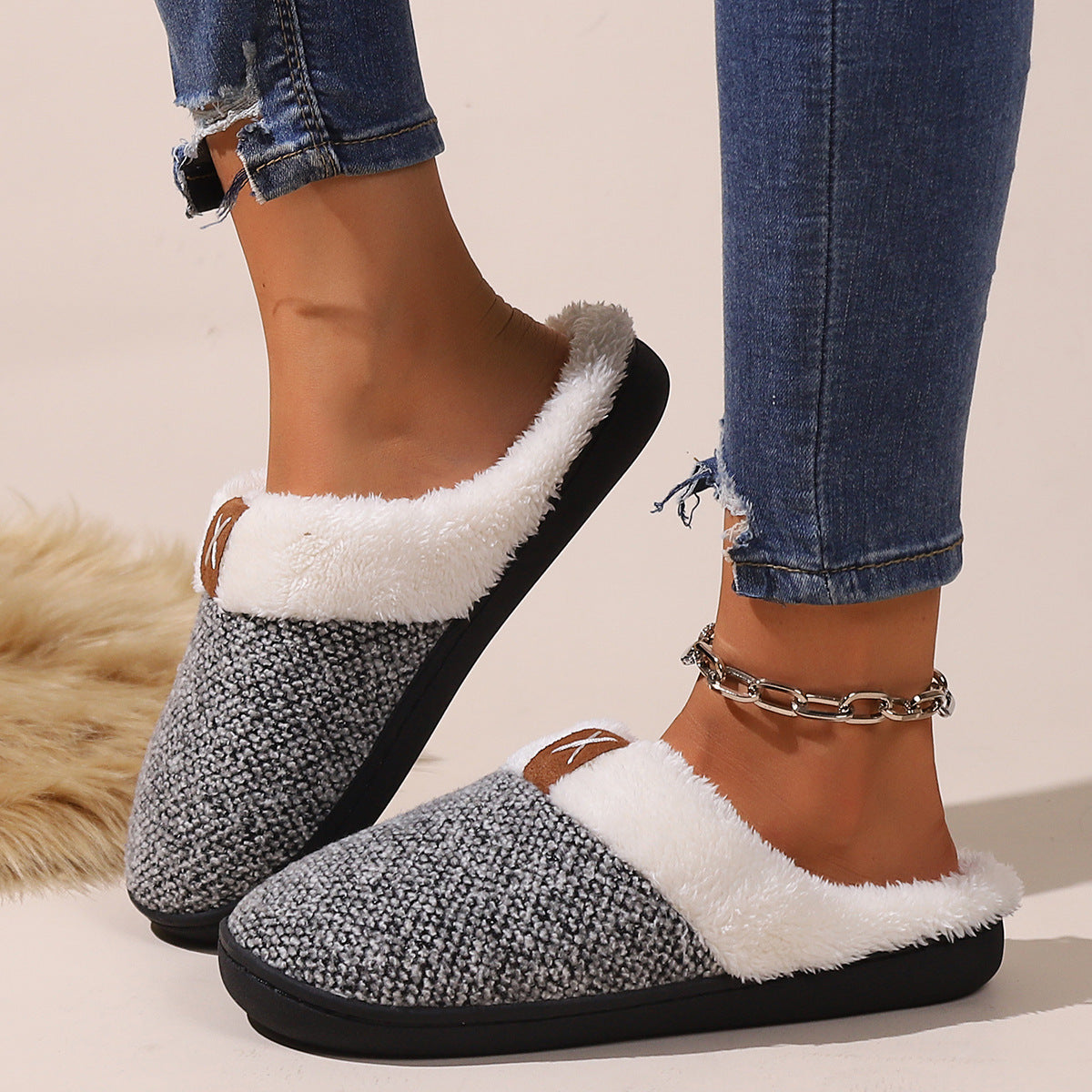 Cozy winter slippers in plush fabric providing warmth and comfort, stylishly worn with jeans.